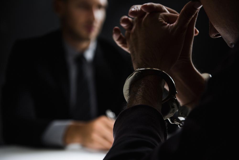 A handcuffed man bows his head during an interrogation over wire-fraud charges. If you are accused of wire fraud in Ohio, contact a criminal defense lawyer who specializes in white-collar crime. These serious accusations can trigger state and federal prosecutions.